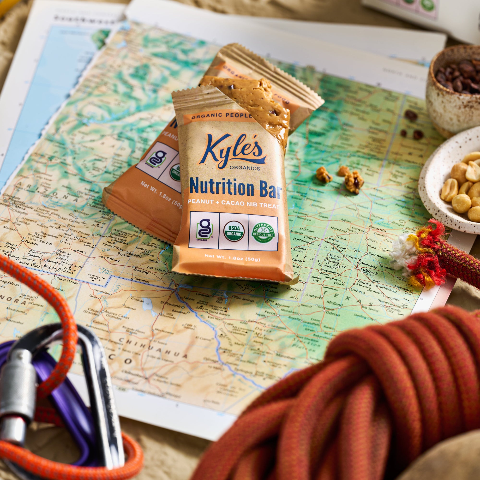 Kyle's Nutrition Bar packages on a map with outdoor gear